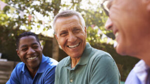 Mature Male Friends Socializing In Backyard Together